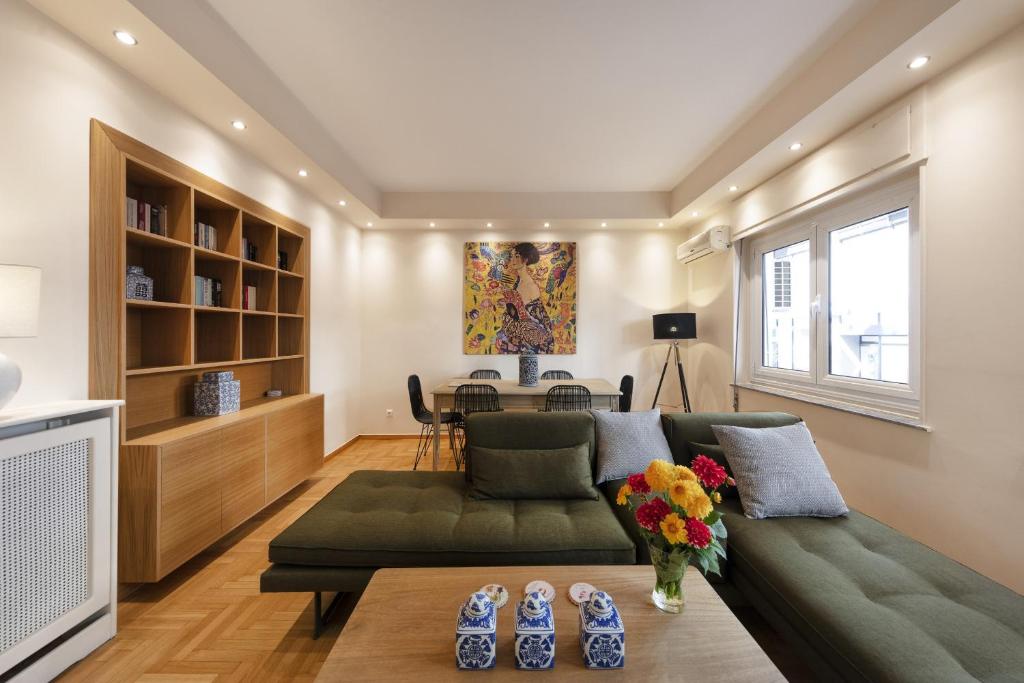 a living room with a green couch and a table at Kolonaki 2 Bdr apartment in Athens