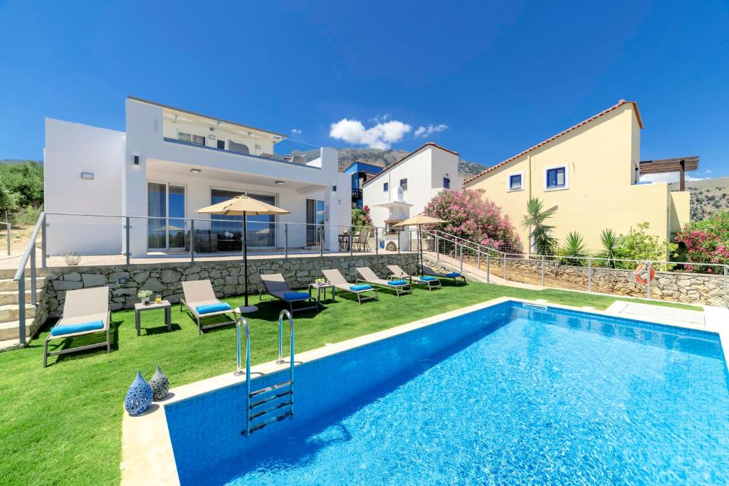 a villa with a swimming pool and a house at Costa Maris Villa in Georgioupoli