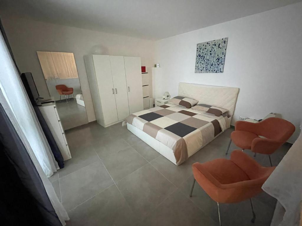 カターニアにあるLa maison de Julienneのベッドルーム1室(ベッド1台、オレンジ色の椅子2脚付)