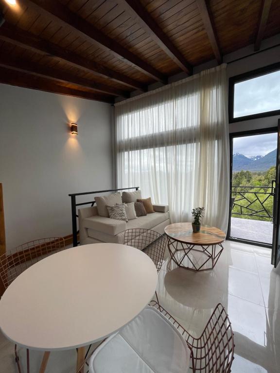 sala de estar con mesa blanca y sillas en Departamento con inmejorable vista a cerros en Villa La Angostura