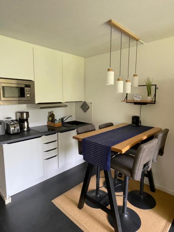 uma cozinha com mesa e cadeiras num quarto em Ferienapartment Auszeit wie dahoam Am Predigtstuhl em Sankt Englmar