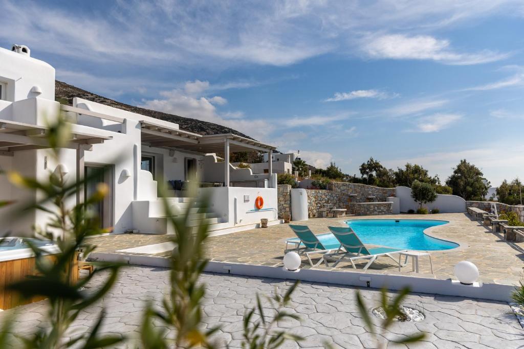 une villa avec une piscine et deux chaises dans l'établissement Villa Livana Naxos, à Kastraki Naxou