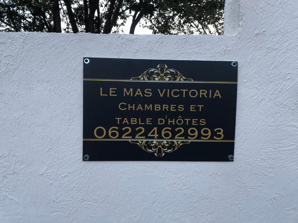 a sign on the side of a white wall at Le Mas Victoria - Chambres d'hôtes avec table d'hôtes-Parking privé ferme in Carcassonne
