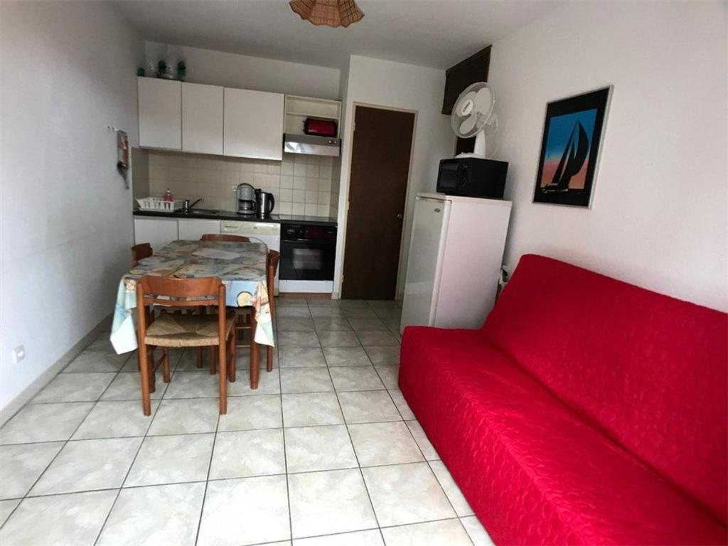 - un salon avec un canapé rouge et une table dans l'établissement Appartement Port Leucate, 3 pièces, 6 personnes - FR-1-81-83, à Port-Leucate
