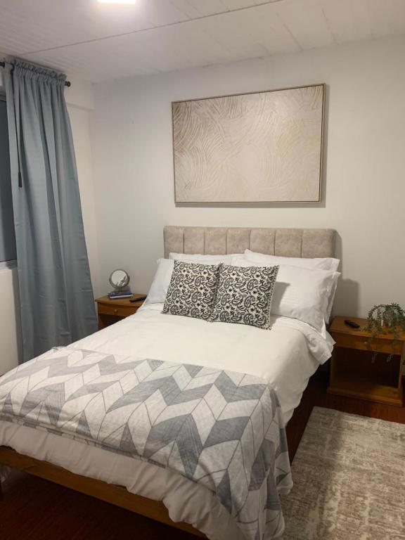 una camera da letto con un grande letto con cuscini sopra di Confortable Apartaestudio a Bogotá
