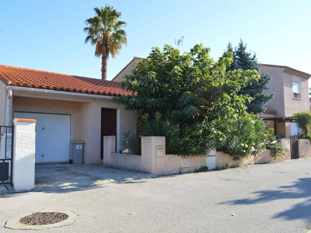 een huis met een garage en een palmboom bij Maison Argelès-sur-Mer, 3 pièces, 6 personnes - FR-1-225-14 in Argelès-sur-Mer