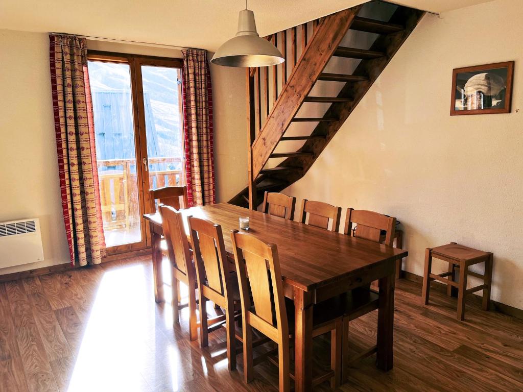 - une salle à manger avec une table et des chaises en bois dans l'établissement VVF Résidence Albiez-Montrond Maurienne, à Albiez-Montrond