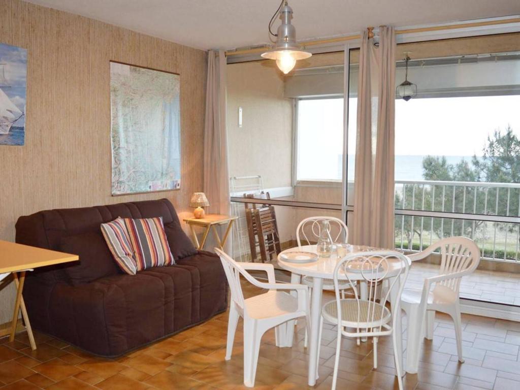 een woonkamer met een bank en een tafel en stoelen bij Appartement Argelès-sur-Mer, 1 pièce, 4 personnes - FR-1-225-100 in Argelès-sur-Mer