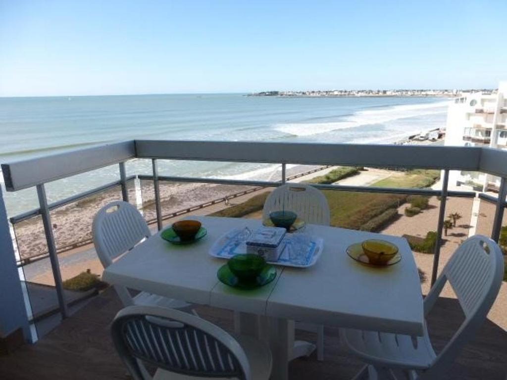 uma mesa e cadeiras numa varanda com praia em Appartement Saint-Gilles-Croix-de-Vie, 2 pièces, 4 personnes - FR-1-224-40 em Saint-Gilles-Croix-de-Vie