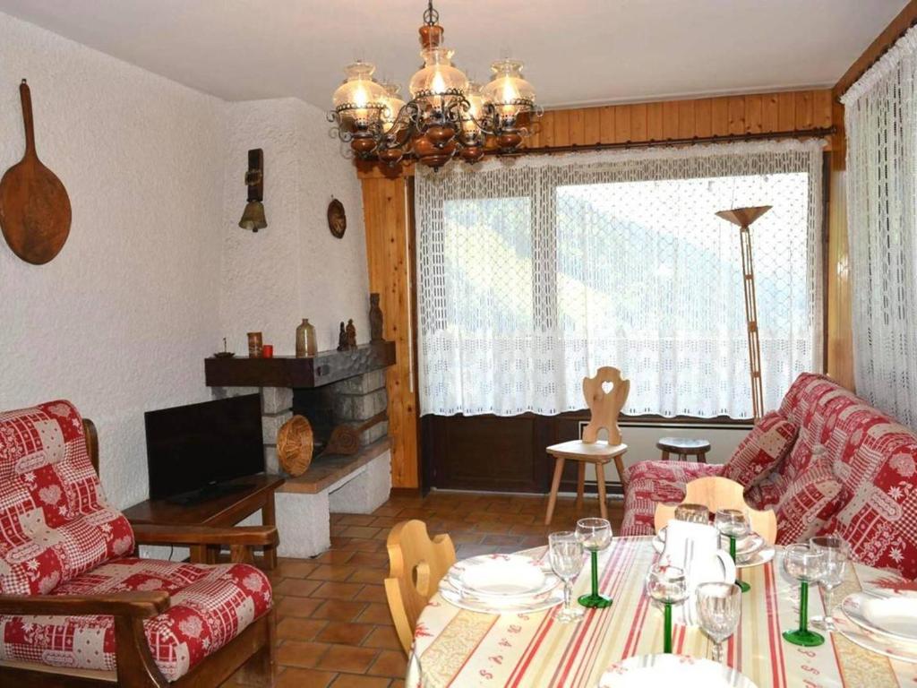 - un salon avec une table et un lustre dans l'établissement Appartement Le Grand-Bornand, 3 pièces, 6 personnes - FR-1-241-42, au Grand-Bornand