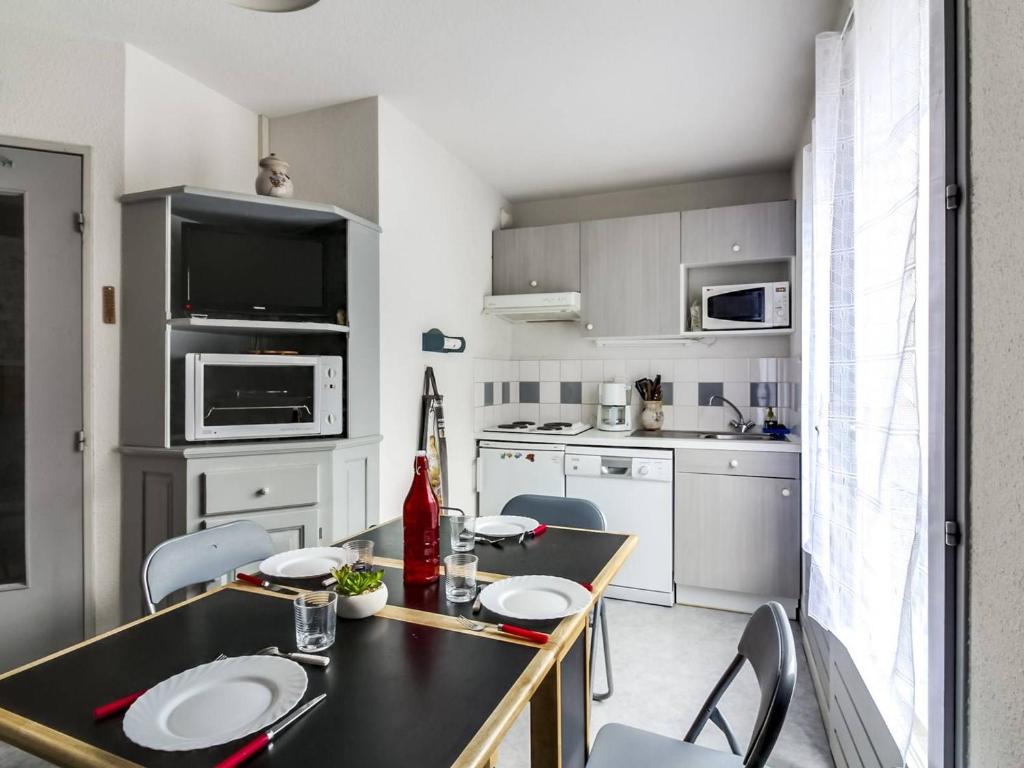 a kitchen with a table and chairs and a kitchen with white cabinets at Appartement 6 pers avec balcon et parking à Barèges - FR-1-403-20 in Barèges
