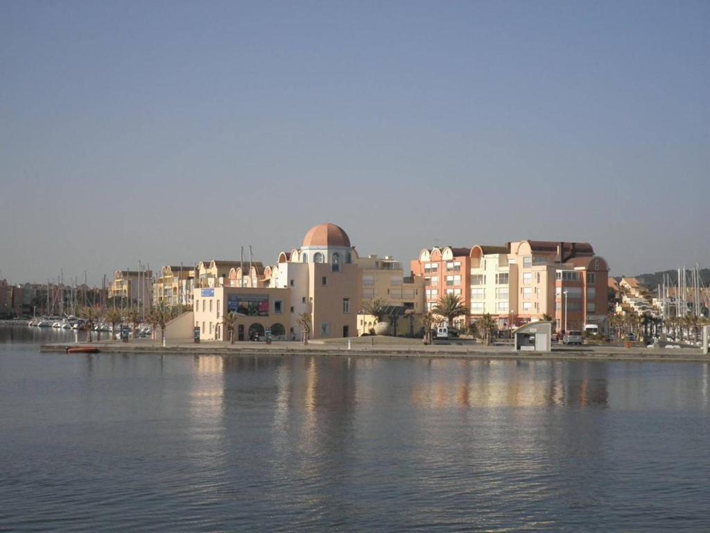 a building next to a body of water with buildings at Appartement Gruissan, 2 pièces, 4 personnes - FR-1-229-292 in Gruissan