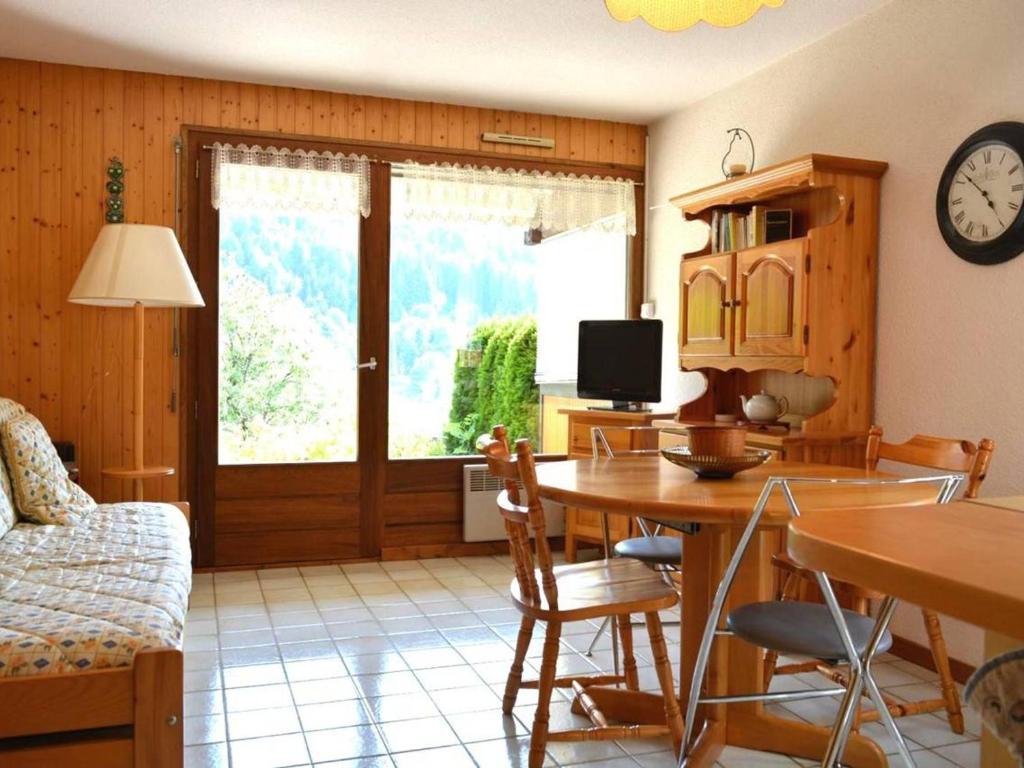 a living room with a dining room table and a clock at Appartement Le Grand-Bornand, 2 pièces, 4 personnes - FR-1-241-91 in Le Grand-Bornand