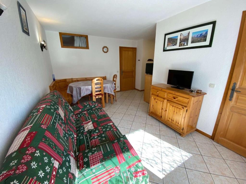 une chambre avec un lit, une télévision et une table dans l'établissement Appartement chaleureux au Grand Bornand - 6 personnes, balcon, parking, proche centre - FR-1-241-131, au Grand-Bornand