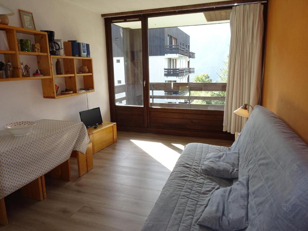 uma sala de estar com uma cama, uma mesa e uma janela em Appartement Peisey-Nancroix-Plan Peisey, 2 pièces, 6 personnes - FR-1-411-79 em Peisey-Nancroix