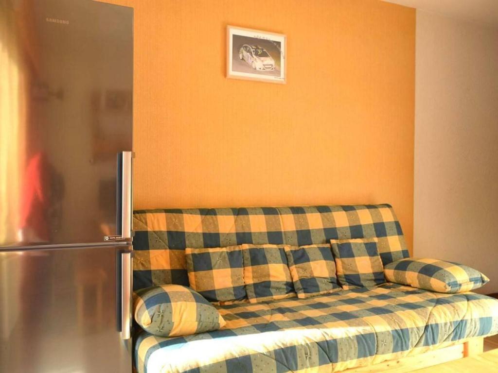 a couch with pillows in a room with a refrigerator at Appartement Le Grand-Bornand, 1 pièce, 4 personnes - FR-1-241-98 in Le Grand-Bornand