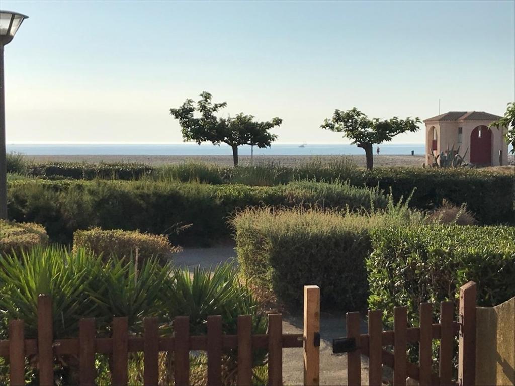 - une vue sur la plage depuis une clôture dans l'établissement Villa 2 Pièces Climatisée avec Terrasse, Face à la Mer, Parking Privé, Proche Commerces et Plage - FR-1-81-343, à Port-Leucate