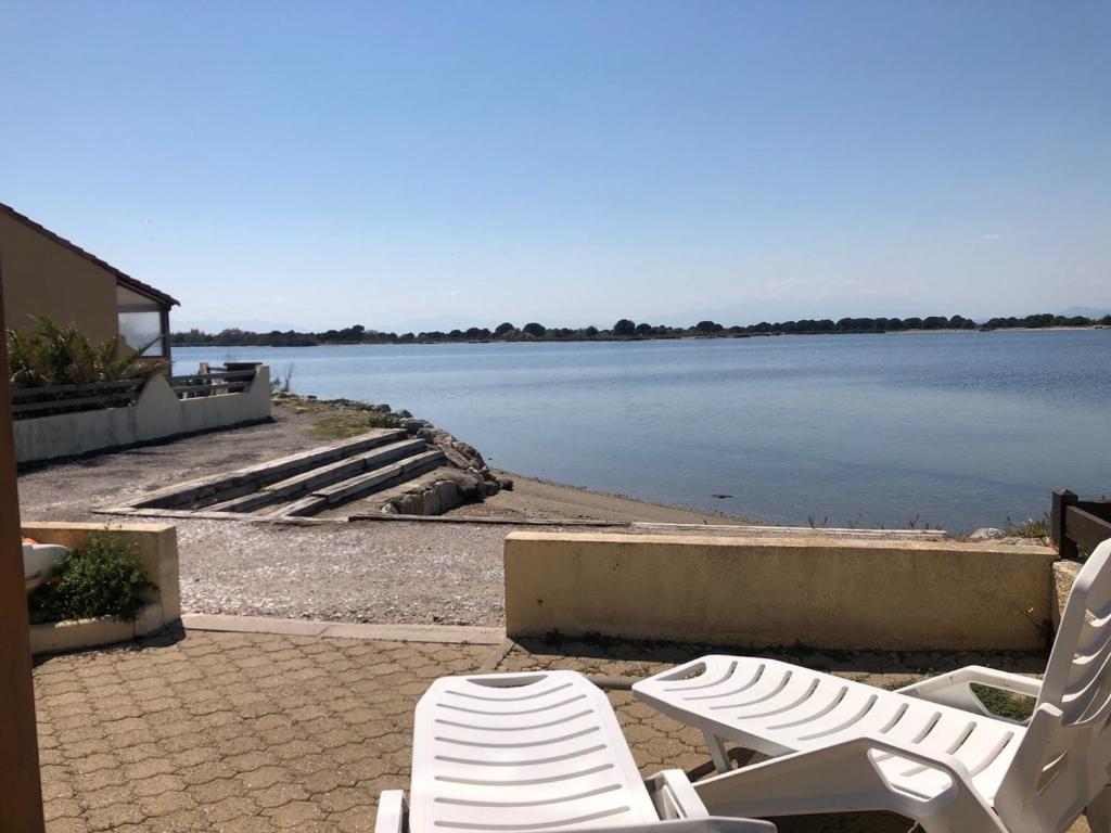 une paire de chaises assises à côté d'une masse d'eau dans l'établissement T2+cabine climatisé avec parking, 4 pers., Port Leucate - FR-1-81-354, à Port-Leucate