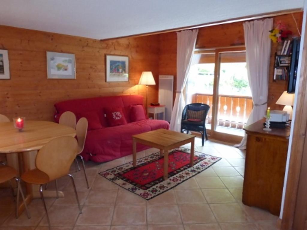 a living room with a red couch and a table at Appartement Méribel, 3 pièces, 6 personnes - FR-1-411-160 in Les Allues