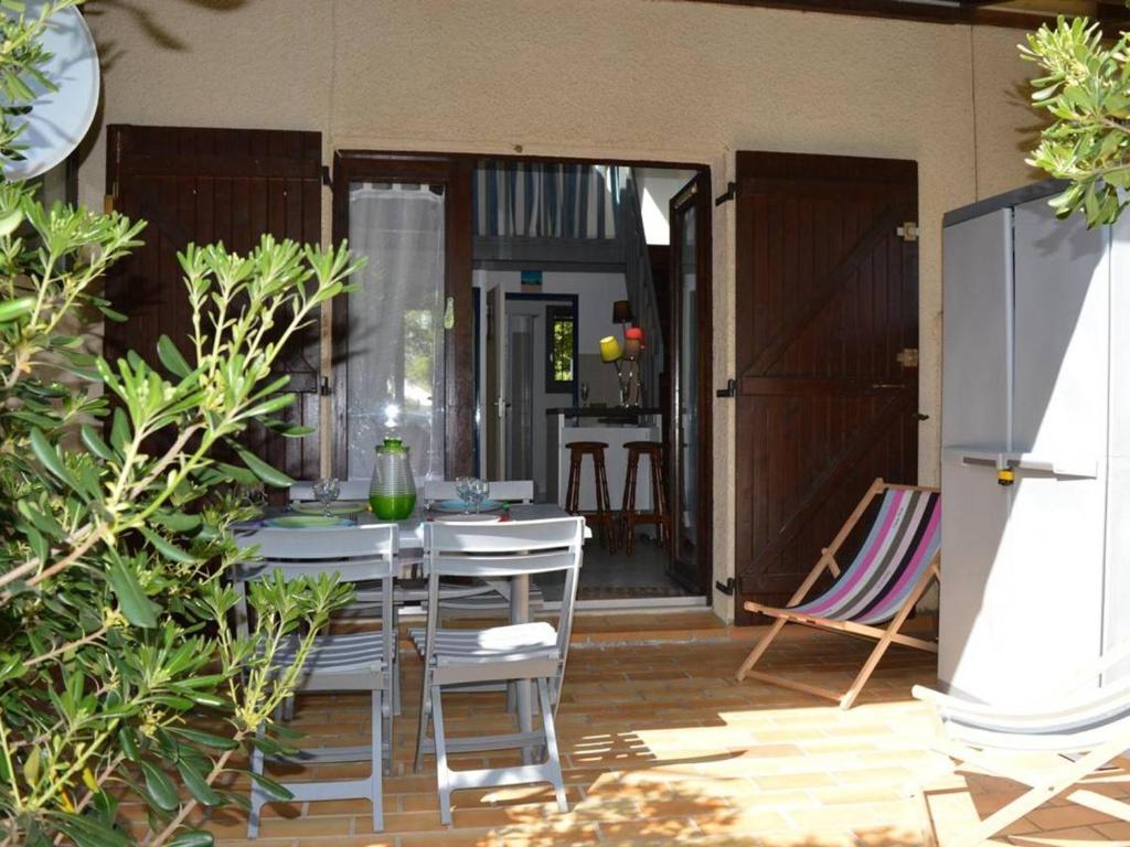 un patio avec une table et des chaises dans une cour dans l'établissement Villa 2 pièces mezzanine, piscine, proche plage, 2 terrasses, BBQ, parking, calme. - FR-1-225D-323, à Saint Cyprien Plage