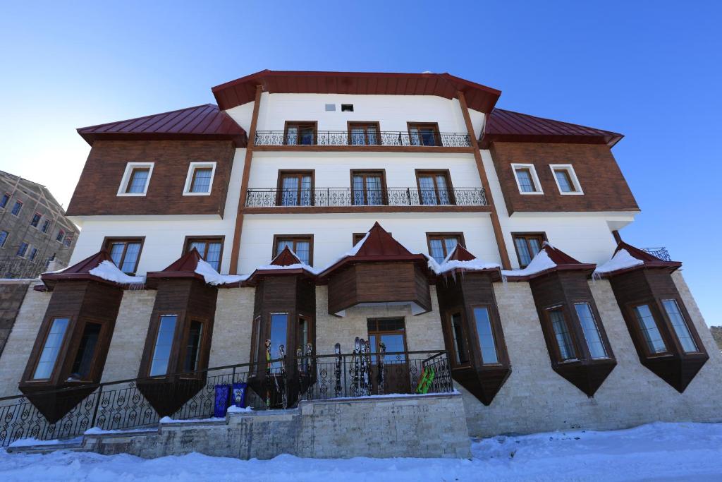 a large building with snow on the ground in front of it at White Park Hotel in Sarıkamıs
