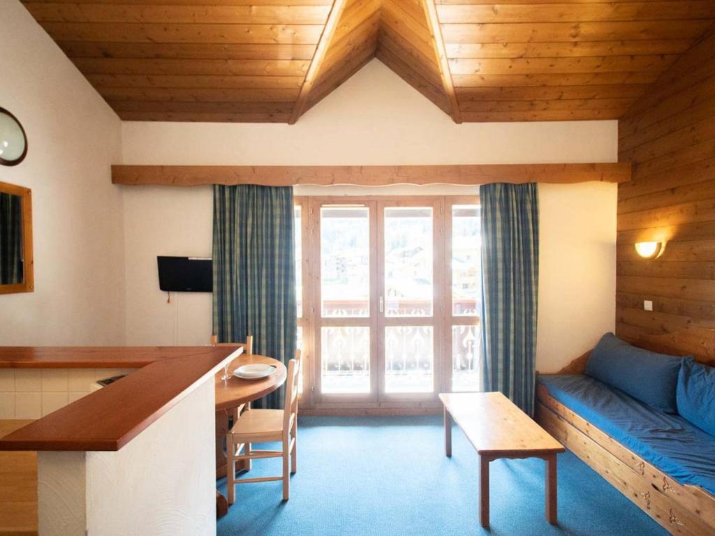 a living room with a blue couch and a table at Appartement Valmorel, 3 pièces, 7 personnes - FR-1-291-708 in Valmorel