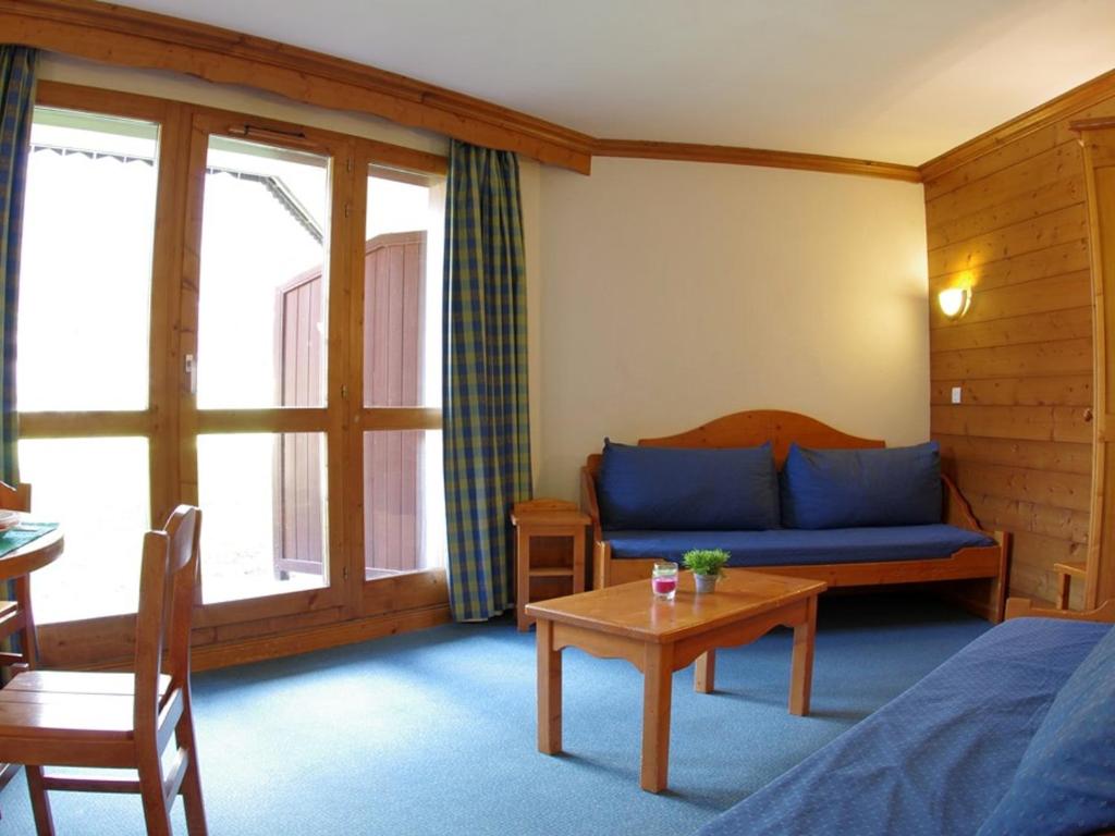 um quarto com um sofá azul e uma mesa em Appartement Valmorel, 3 pièces, 7 personnes - FR-1-291-726 em Valmorel