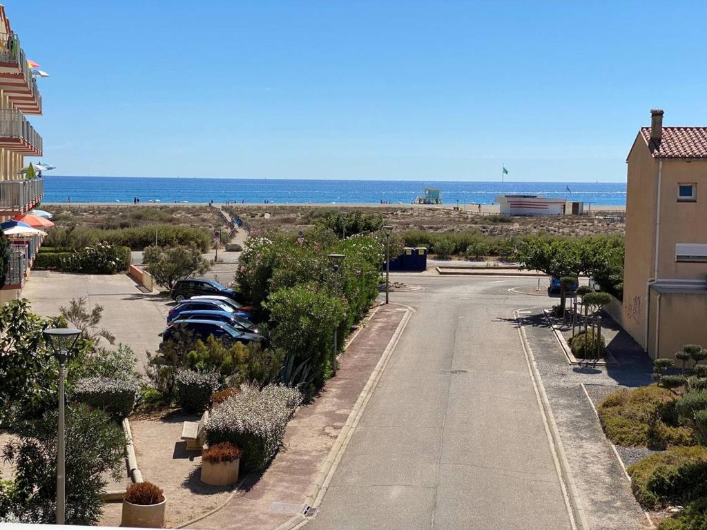 un estacionamiento vacío con el océano en el fondo en Appartement T2, 4 pers, bord de plage, Parking privé, Lave-linge - FR-1-81-274, en Le Barcarès