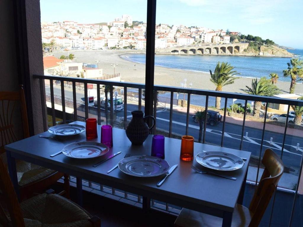 d'une table avec vue sur la plage depuis un balcon. dans l'établissement Appartement 3 pièces, central, proche plage, 6 couchages, vue mer, lave-vaisselle, animaux admis - FR-1-225C-318, à Banyuls-sur-Mer