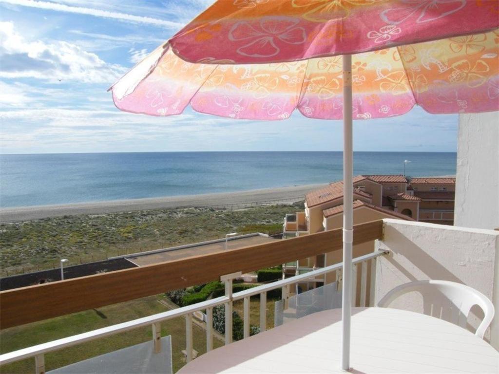 une terrasse avec un parasol et l'océan dans l'établissement Superbe T2 à Port Barcarès, plage à pied, parking privé - FR-1-81-295, à Port-Leucate