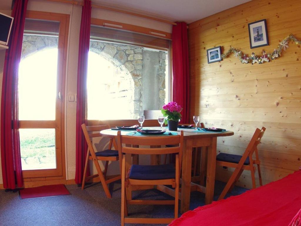 a dining room with a table and chairs and a window at Studio Valmorel, 2 pièces, 4 personnes - FR-1-291-772 in Valmorel