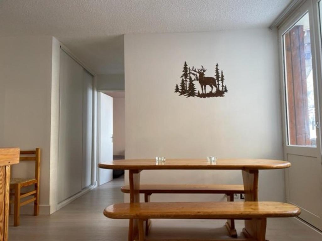 une salle à manger avec une table et deux bancs dans l'établissement Appartement 3 pièces, 7 pers. avec WIFI, à 20m des pistes, balcons et casier à skis - FR-1-262-77, à Forest des Baniols