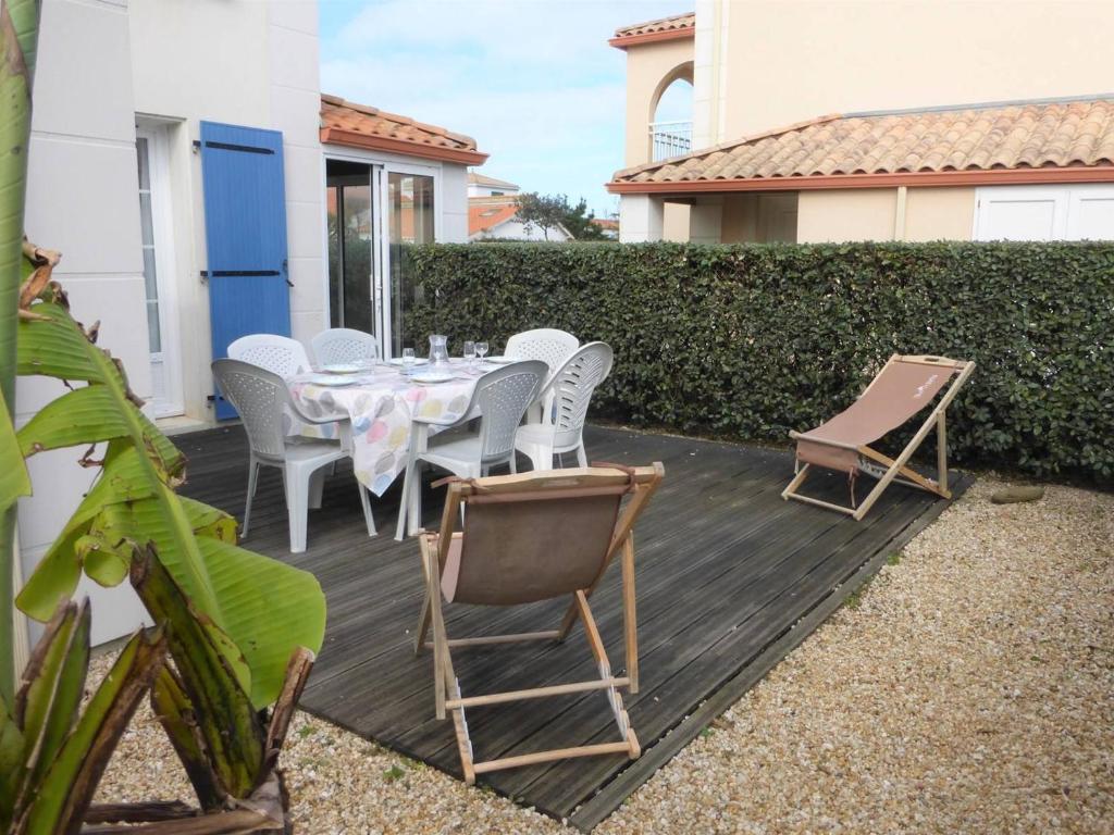 un patio avec une table et des chaises sur une terrasse dans l'établissement Maison 4 pièces avec piscine, 300m plage, 6 couchages, Bretignolles-sur-Mer - FR-1-224A-26, à Bretignolles-sur-Mer