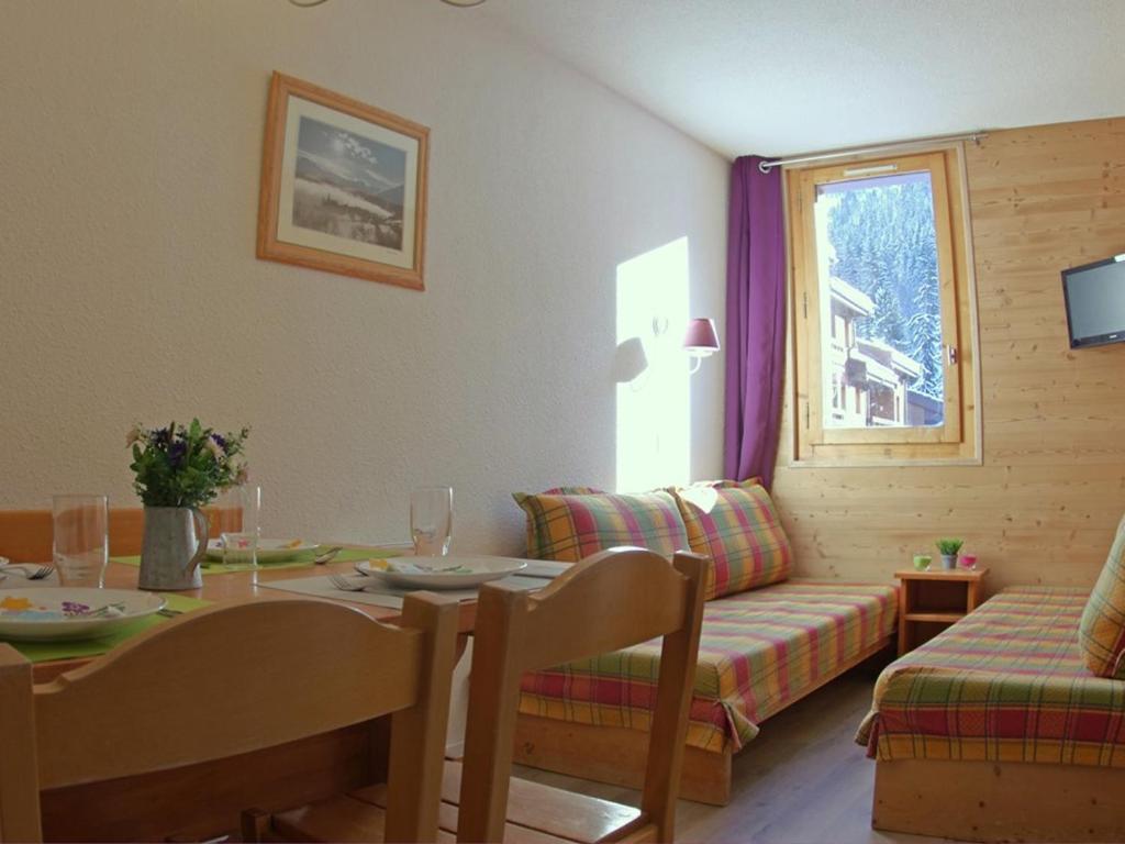 un salon avec une table et un canapé dans l'établissement Studio divisible rénové avec balcon et animaux acceptés à Valmorel - FR-1-291-788, à Valmorel