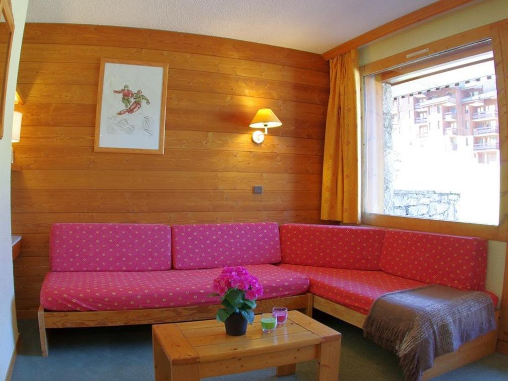 a living room with a red couch and a table at Appartement Valmorel, 1 pièce, 4 personnes - FR-1-291-783 in Valmorel