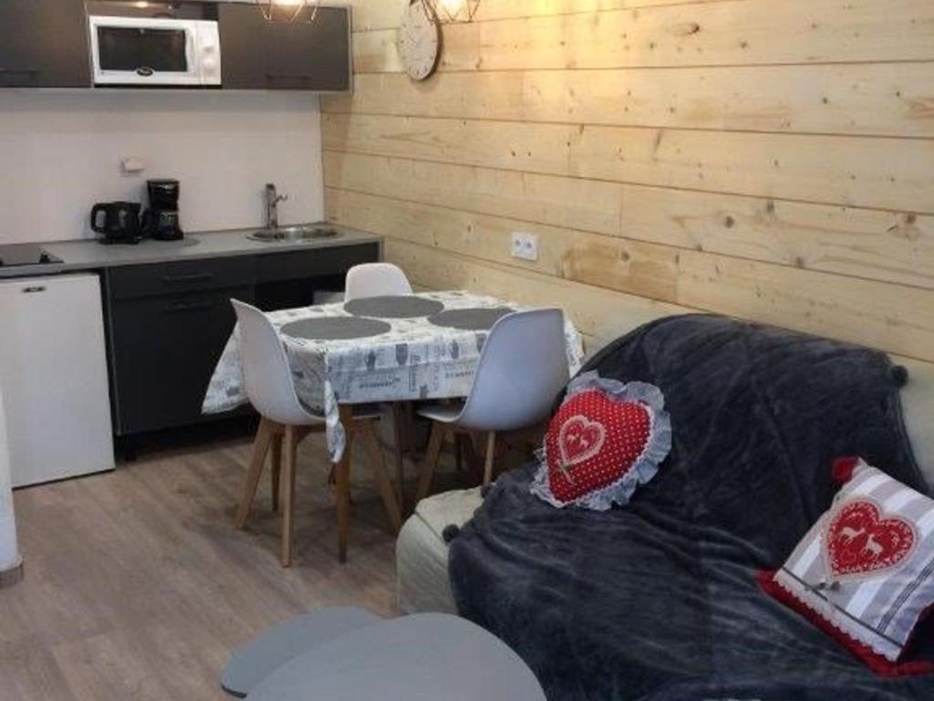 un salon avec un canapé et une table avec des chaises dans l'établissement Appartement T2 avec Balcon, Centre de Cauterets, Près des Thermes et Remontées Mécaniques - FR-1-234-121, à Cauterets