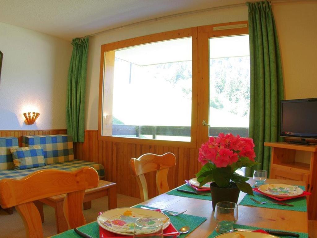 a living room with a table and a window at Appartement 2 pièces à Valmorel pour 6 pers, balcon, animaux acceptés - FR-1-291-764 in Valmorel