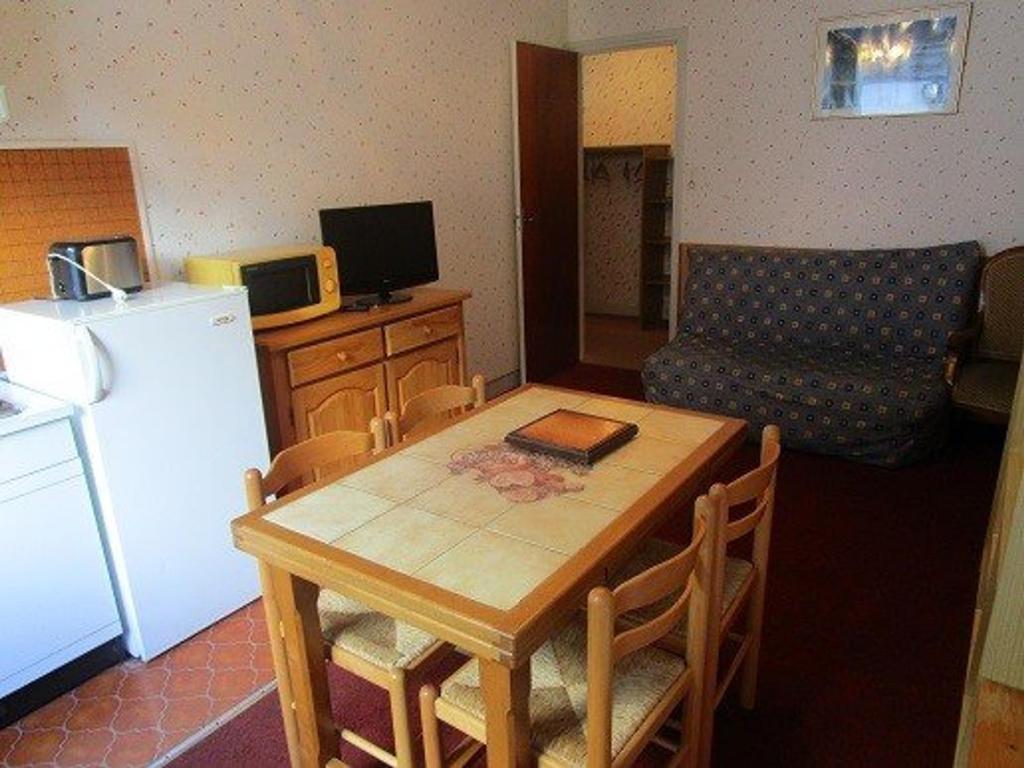 uma pequena cozinha com uma mesa e um frigorífico em Appartement Cauterets, 3 pièces, 4 personnes - FR-1-234-141 em Cauterets