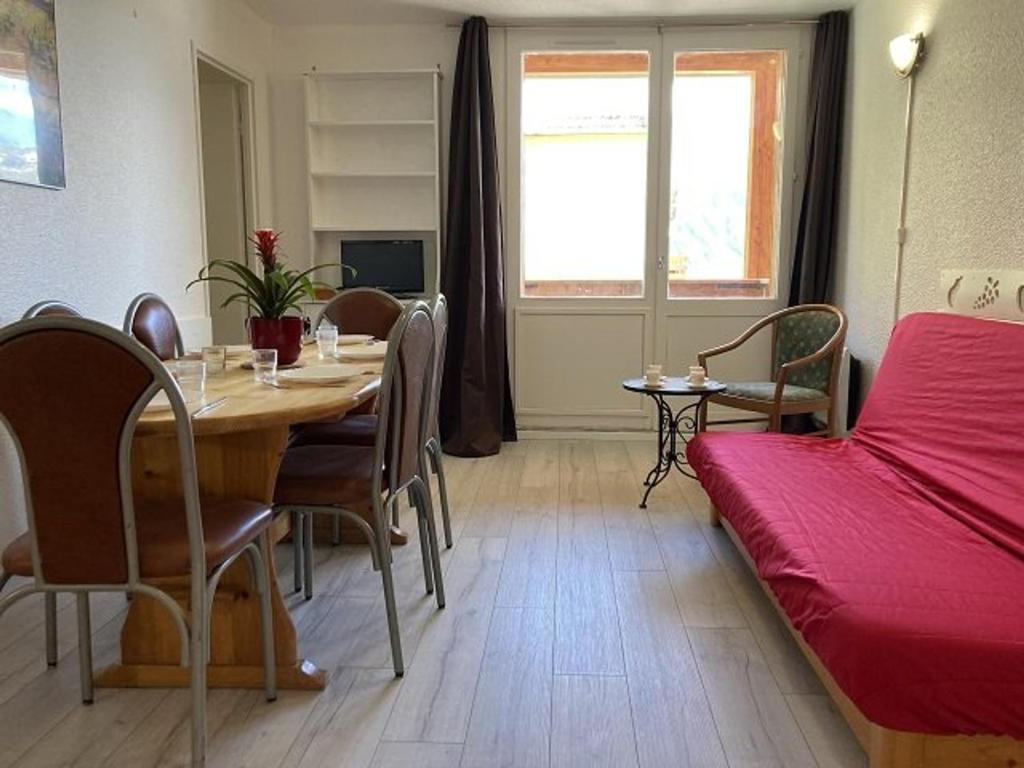 Forest des BaniolsにあるAppartement Orcières Merlette, 2 pièces, 6 personnes - FR-1-262-80のテーブル、椅子、ベッドが備わる客室です。