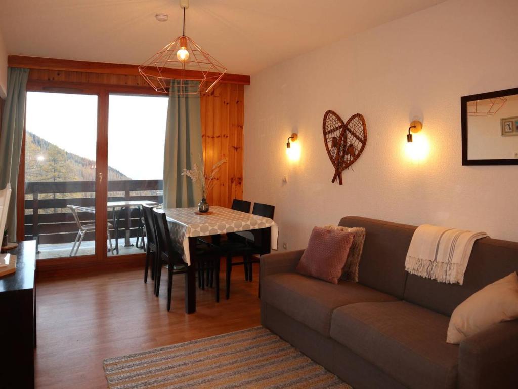 un salon avec un canapé et une table dans l'établissement Appartement au pied des pistes avec piscine, sauna et hammam, 4 pers - FR-1-322-33, aux Orres