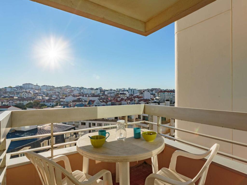une table et des chaises sur un balcon avec vue dans l'établissement Charmant studio en centre-ville avec piscine proche Grande Plage - FR-1-3-410, à Biarritz