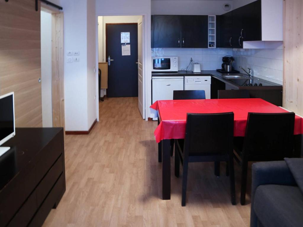 cocina con mesa roja y sillas negras en Appartement Les Orres, 1 pièce, 6 personnes - FR-1-322-95 en Les Orres