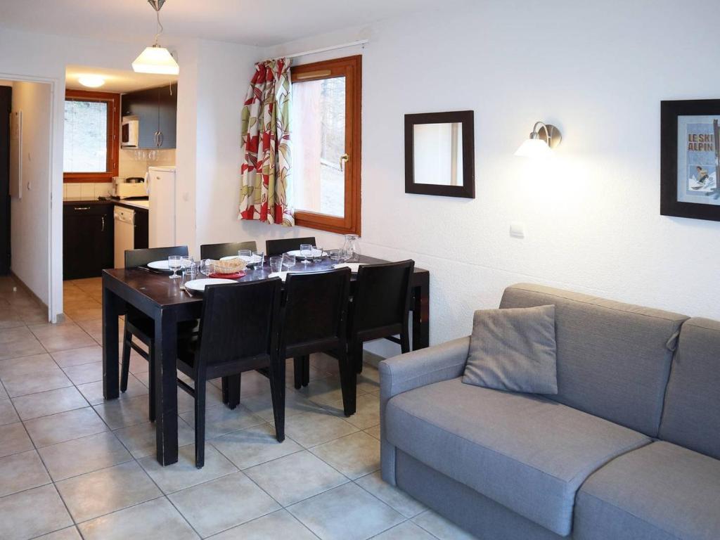 a dining room with a table and a couch at Chalet Les Orres, 3 pièces, 6 personnes - FR-1-322-110 in Les Orres