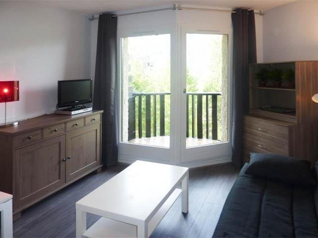 ein Wohnzimmer mit einem Sofa und einem TV in der Unterkunft Studio Les Orres, 1 pièce, 4 personnes - FR-1-322-115 in Les Orres