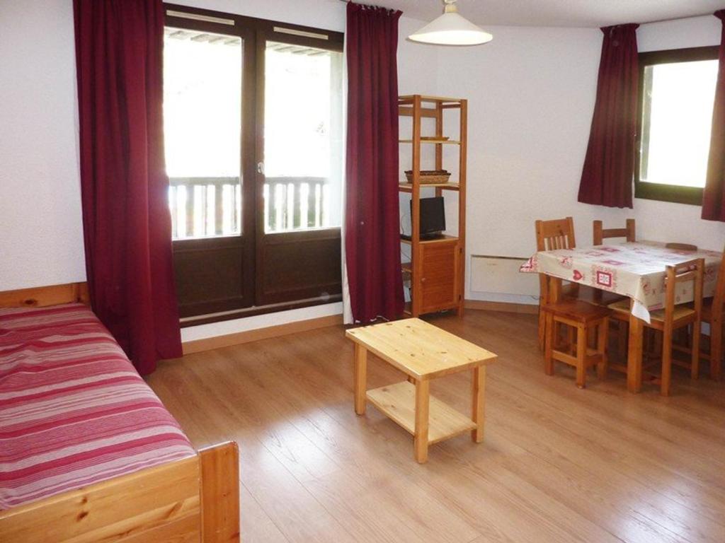une chambre avec un lit, une table et un bureau dans l'établissement Studio idolâtrable aux Orres pour 4, accès pistes, balcon - FR-1-322-132, aux Orres