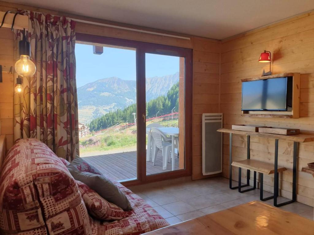 ein Wohnzimmer mit einem TV und einem großen Fenster in der Unterkunft Chalet Les Orres, 3 pièces, 6 personnes - FR-1-322-121 in Les Orres