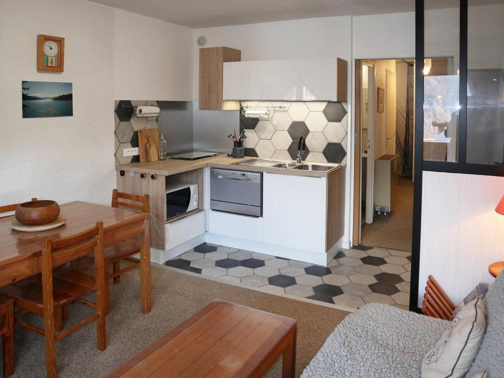 een keuken en een woonkamer met een tafel, een keuken en een eetkamer bij Studio Les Orres, 1 pièce, 4 personnes - FR-1-322-84 in Les Orres