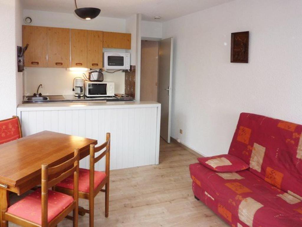 ein Wohnzimmer mit einem Tisch und einer Küche in der Unterkunft Appartement Les Orres, 1 pièce, 4 personnes - FR-1-322-271 in Les Orres
