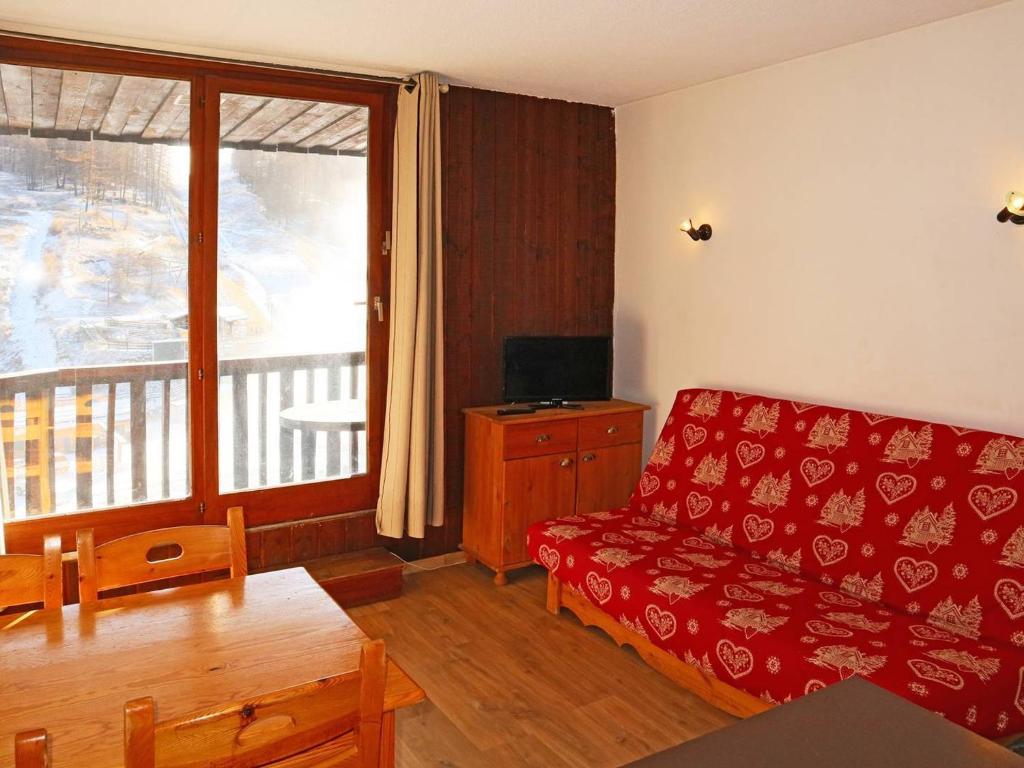- un salon avec un canapé rouge et une fenêtre dans l'établissement Studio confortable pour 4 pers., skis aux pieds, animaux admis - FR-1-322-151, aux Orres