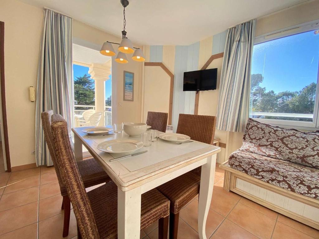 une salle à manger avec une table et un canapé dans l'établissement Appartement T2 avec Piscine à 300m de la Plage – 3 Couchages, Parking et Balcon Meublé - FR-1-245-34, à La Baule